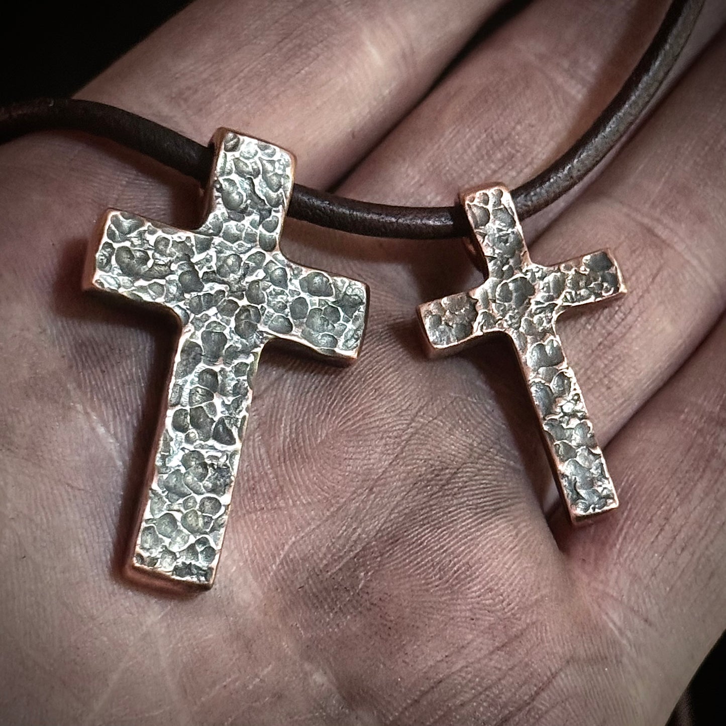 Petite cross next to the regular hammered copper cross